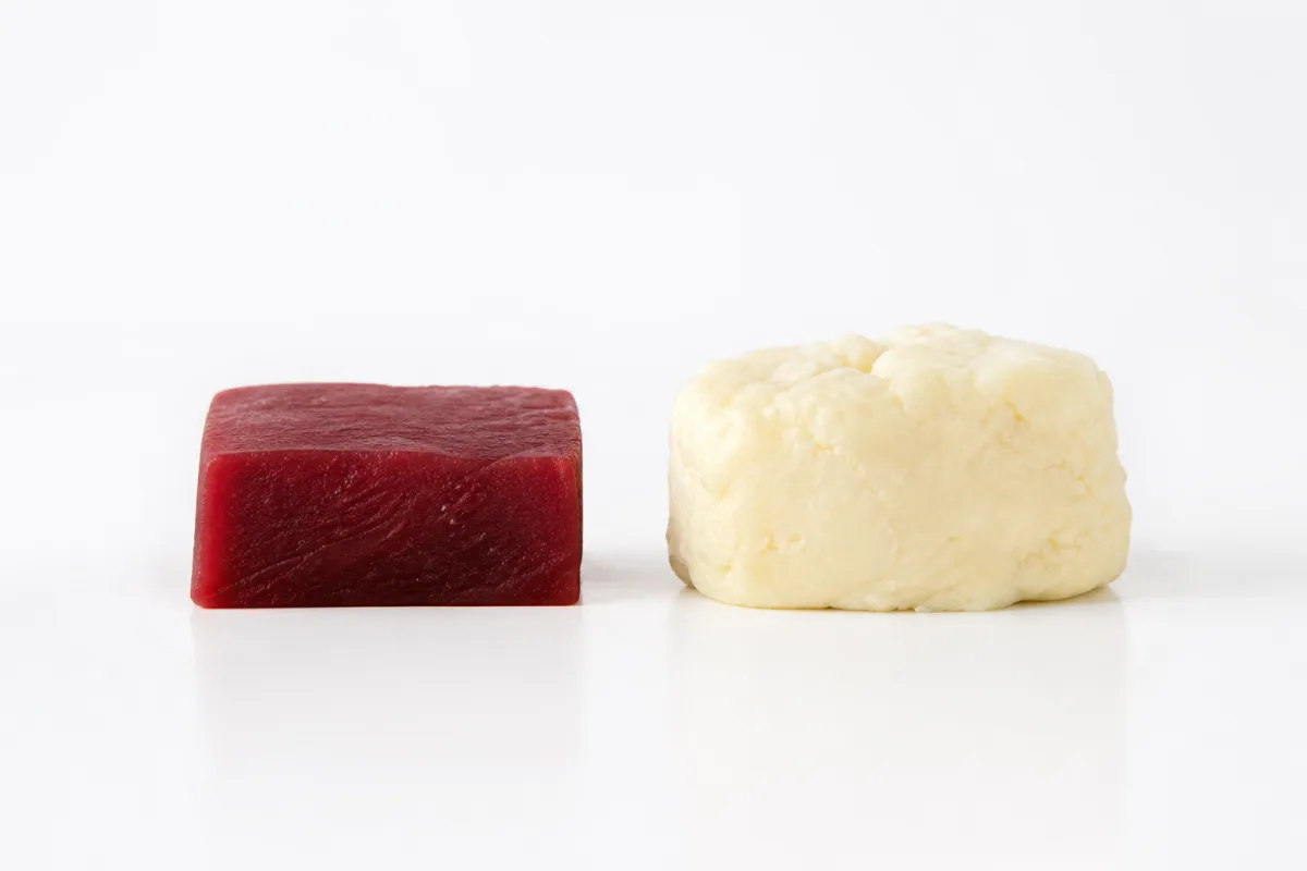 A dense red block beside a slightly larger pale mass of equal weight, showing the modest real difference in volume between muscle and fat